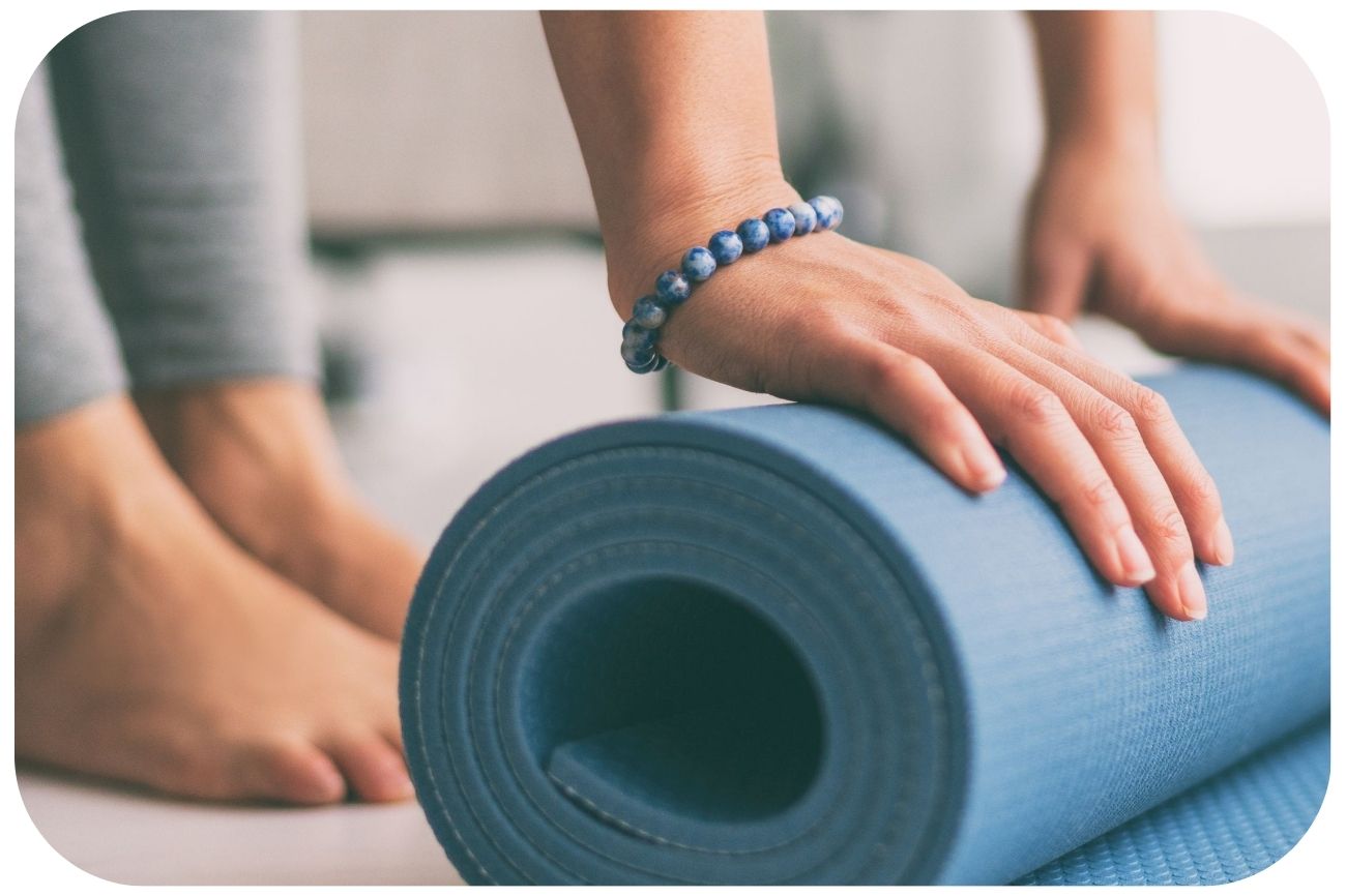 Sport bei Rosacea, Frau rollt Gymnastikmatte ein