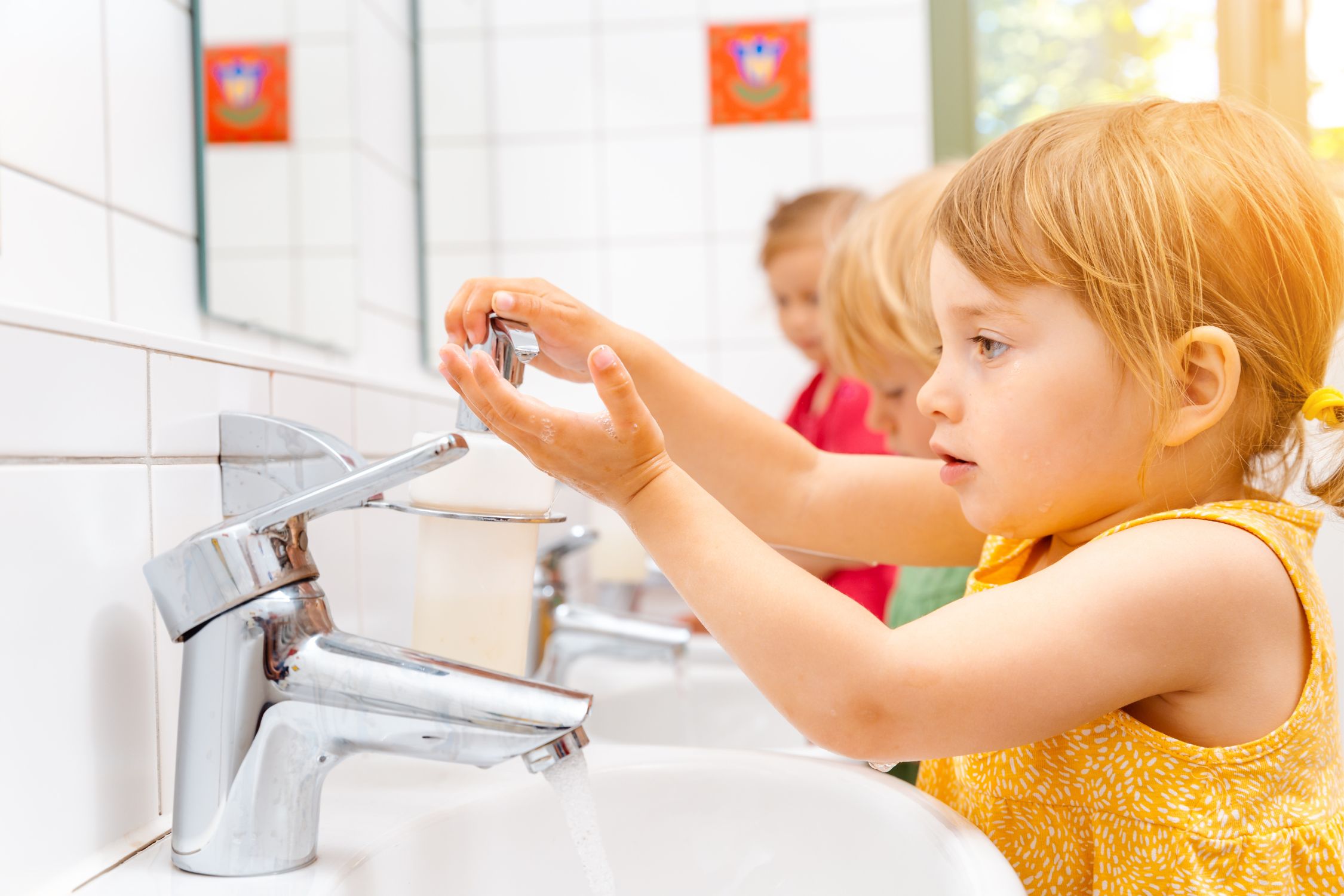 Kinder waschen sich im Waschraum des Kindergartens gemeinsam die Hände