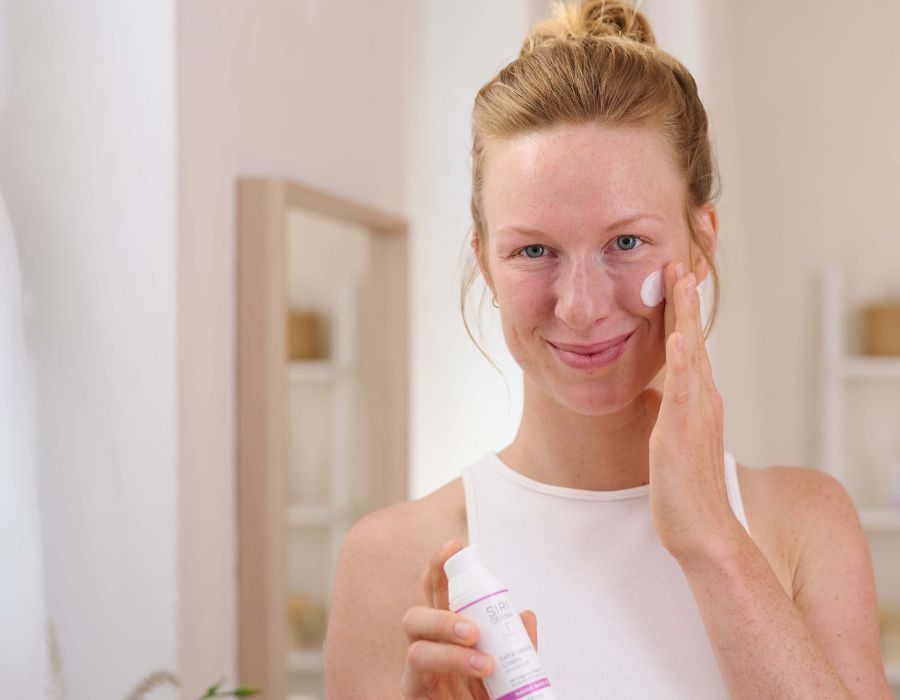 Frau cremt sich das Gesicht mit SIRIDERMA Creme ein