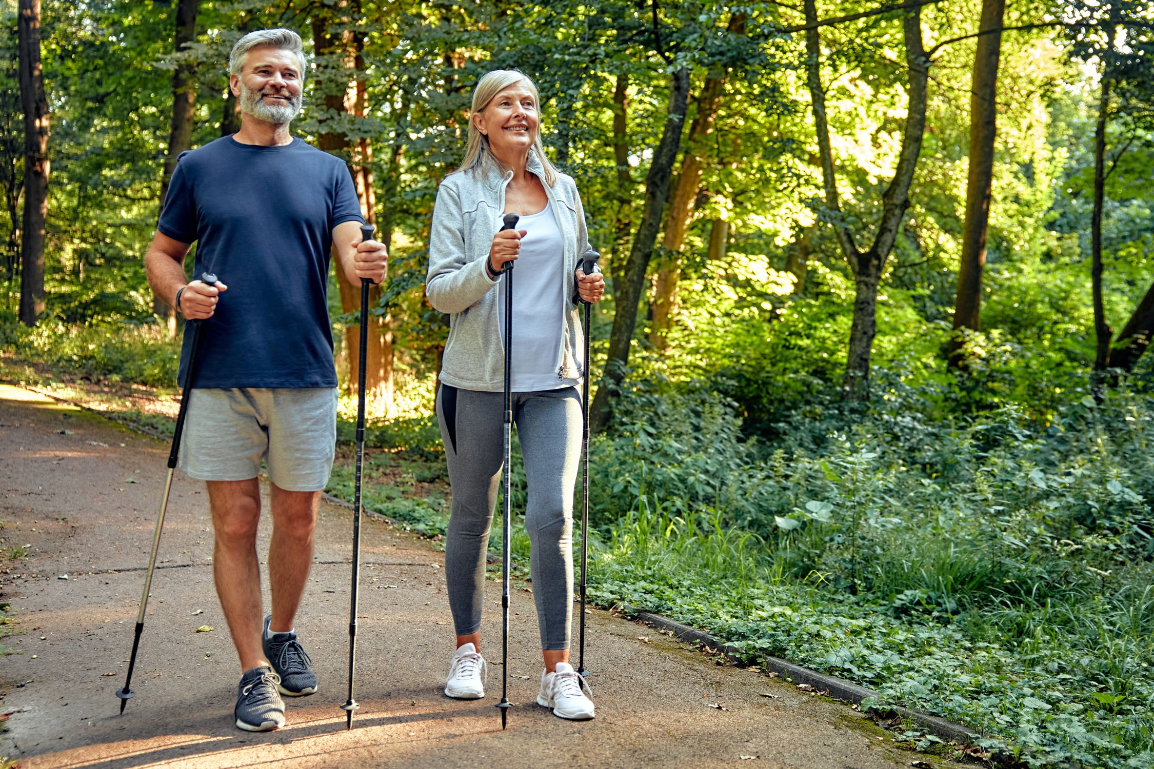 Mann und Frau beim Nordic Walking im Park, mederate Sportarten tun bei Rosacea gut