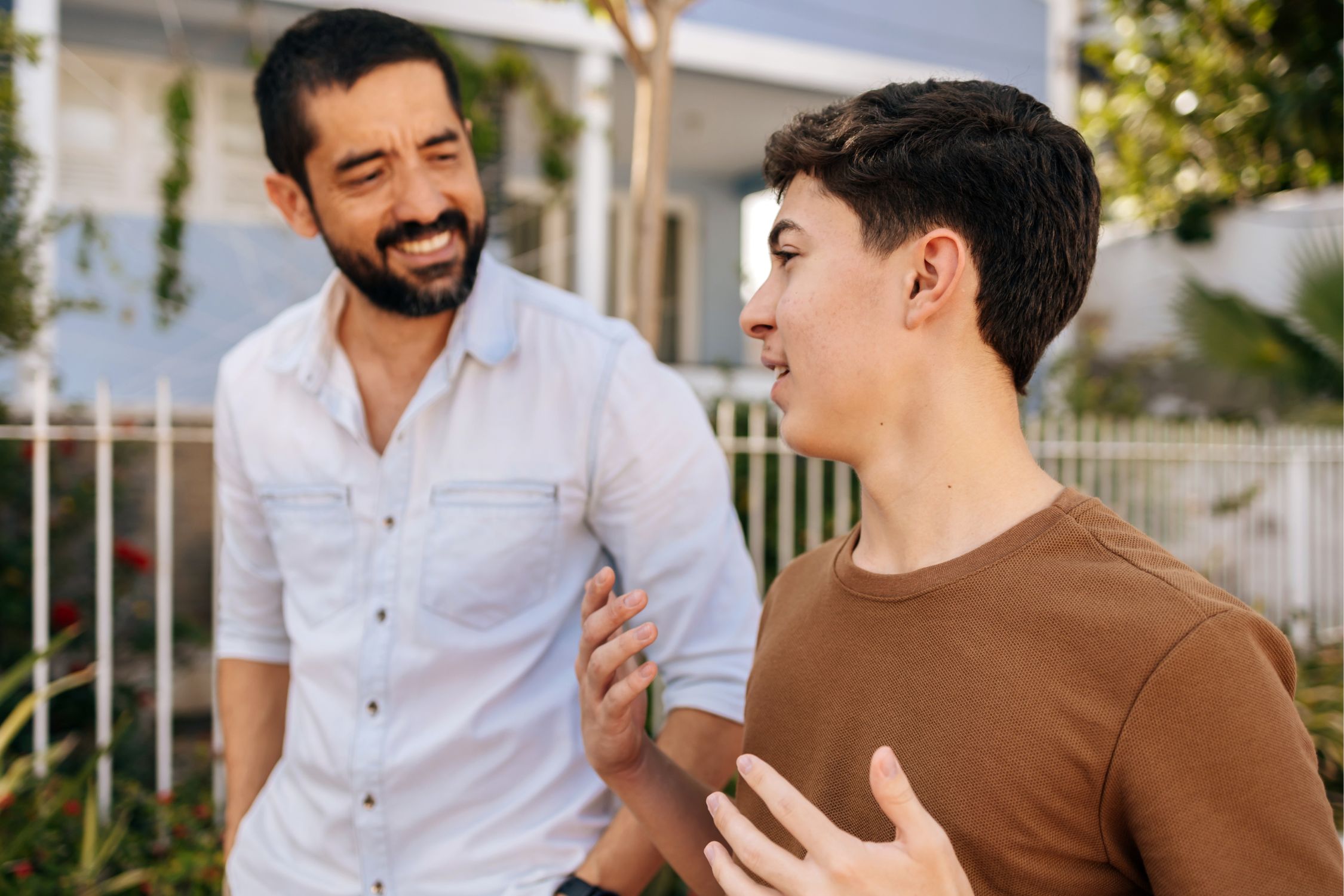 Jugendlicher und Vater unterhalten sich freundlich beim Spaziergang draußen