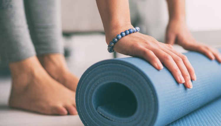 Sport bei Rosacea, Frau rollt Gymnastikmatte ein