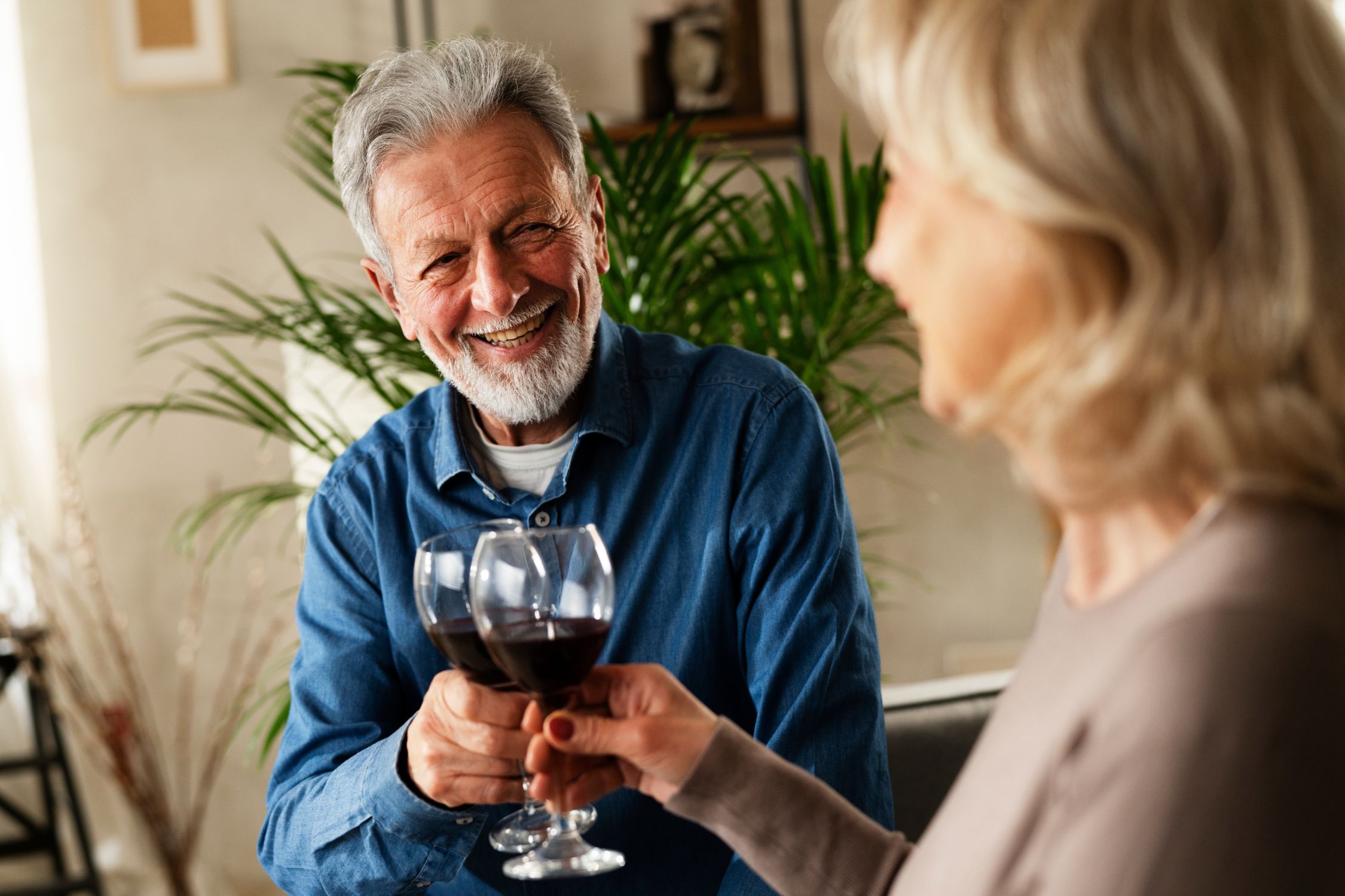 Ein Mann und eine Frau stoßen mit zwei Gläsern Rotwein an