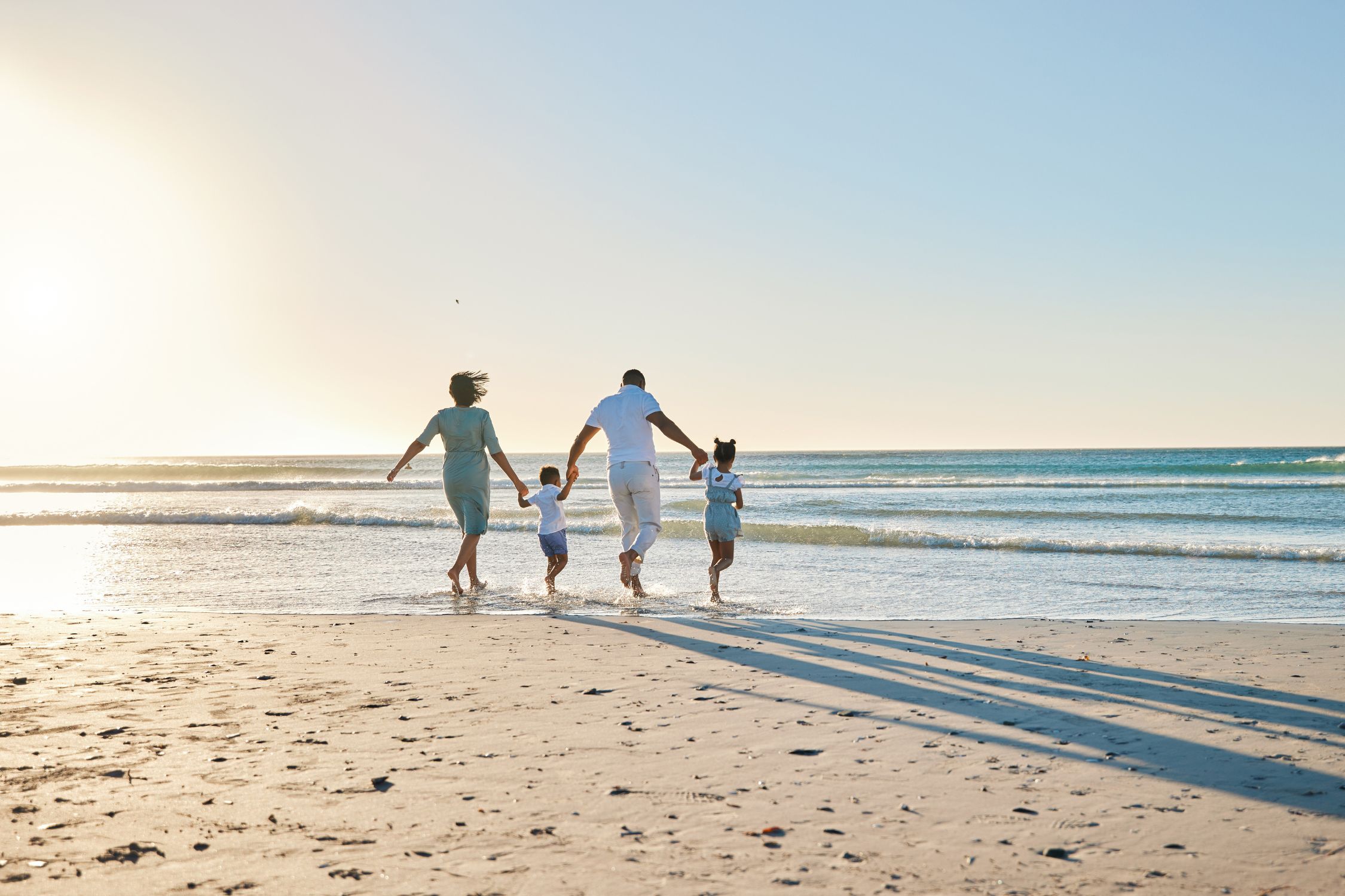 Mutter, Vater und zwei Kinder am Strand